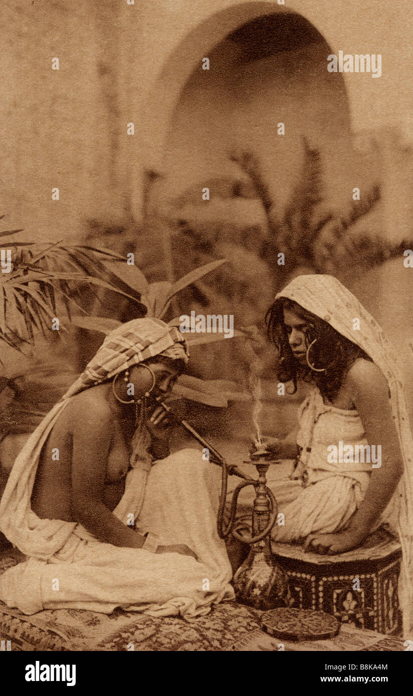 Harem girls smoking hookah.  From an early 20th century postcard Stock Photo