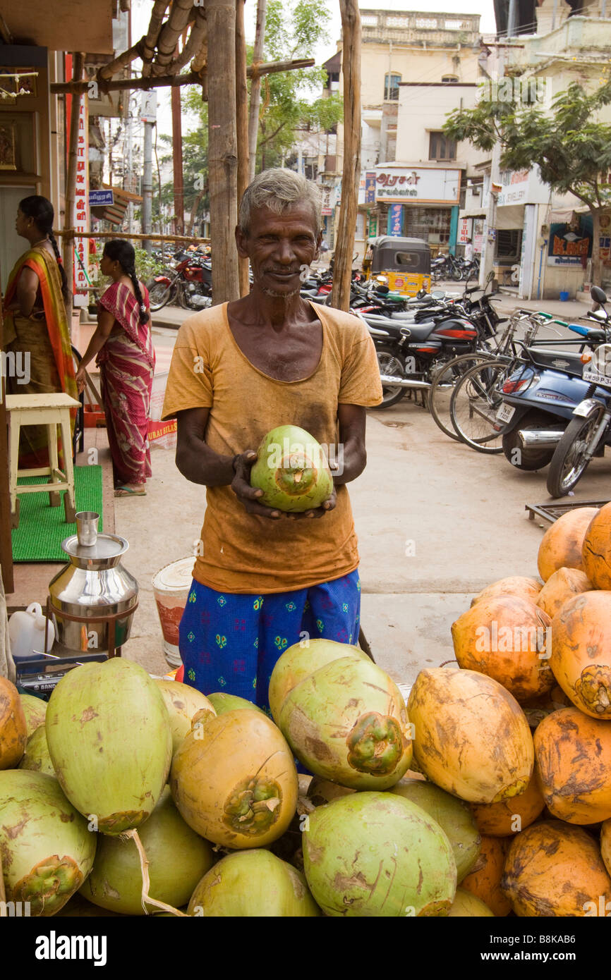 India Tamil Nadu Madurai man selling fresh young coconuts to drink
