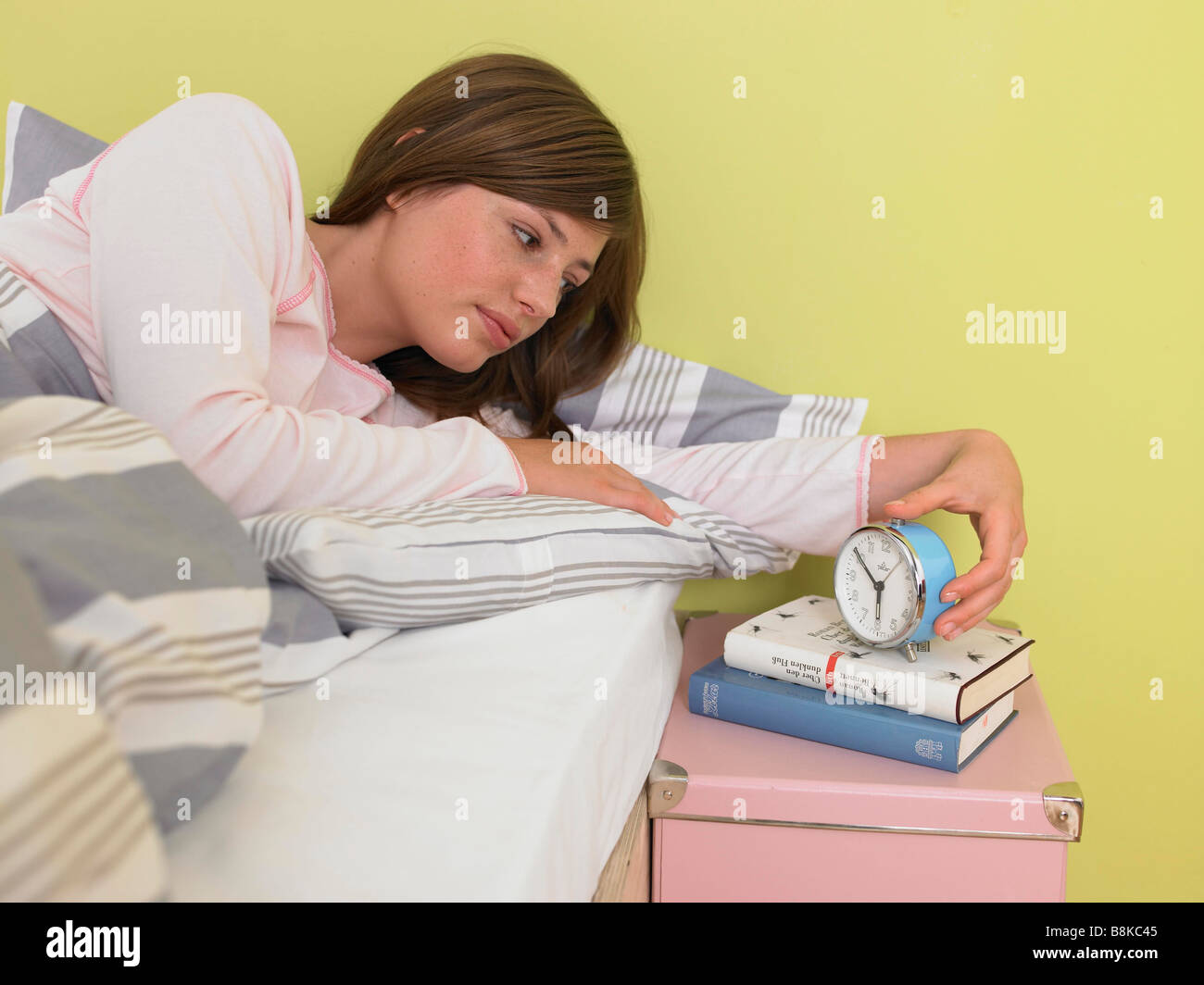 Woman looking at the alarmclock Stock Photo