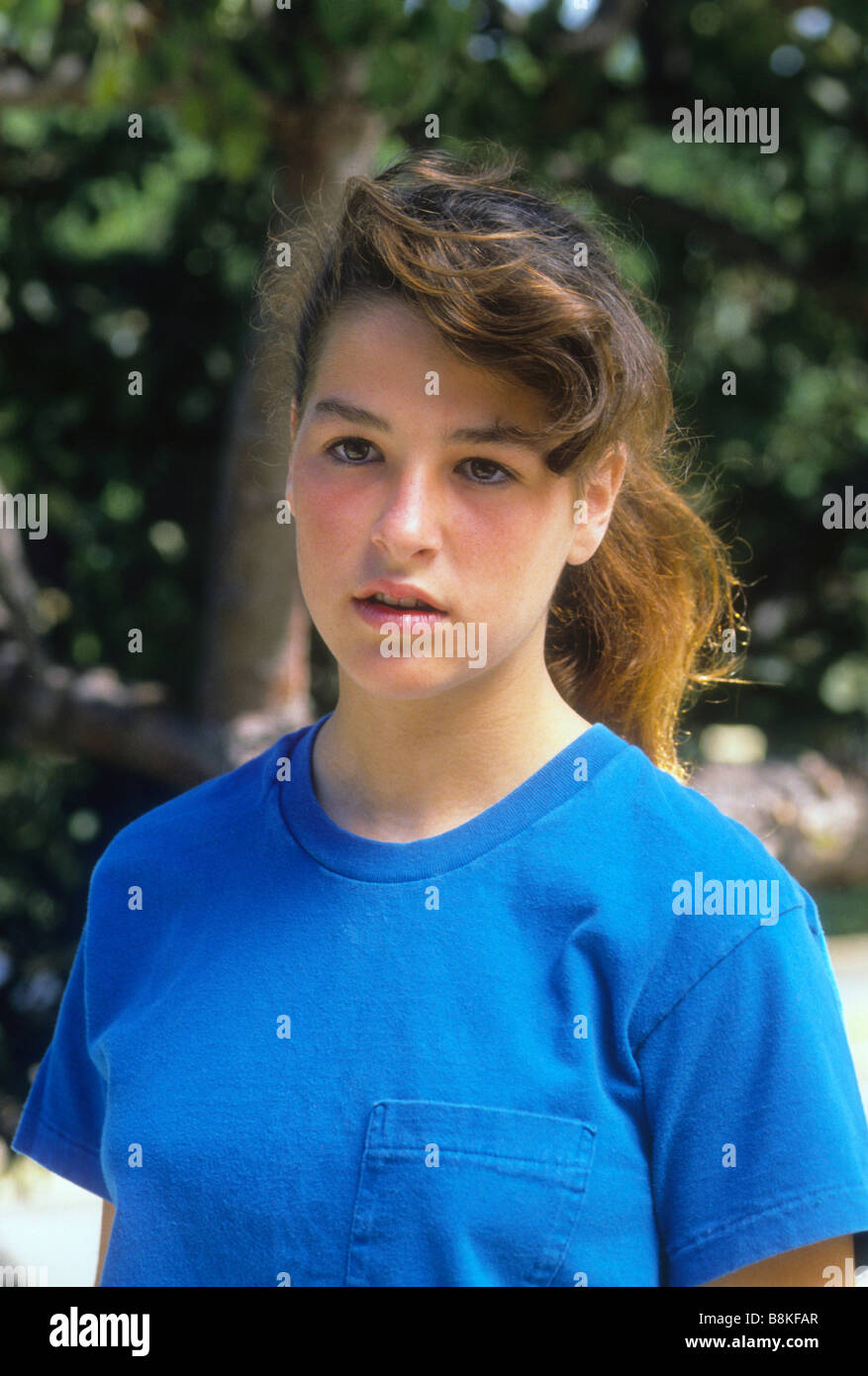 Teen girl in blue shirt with serious expression on face Stock Photo