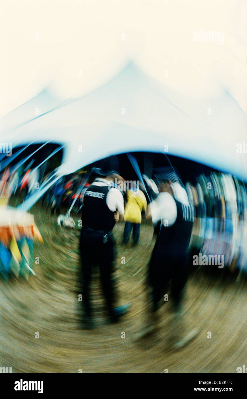 Glastonbury Festival, two police officers enjoy music playing in the Acoustic Stage Tent Stock Photo