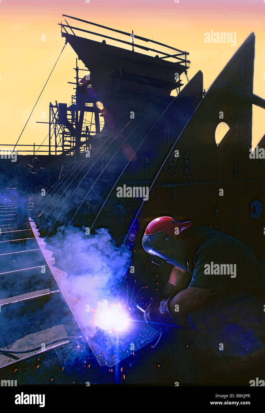 Welder welding structural steel during construction of ship at California shipbuilding yard. Stock Photo