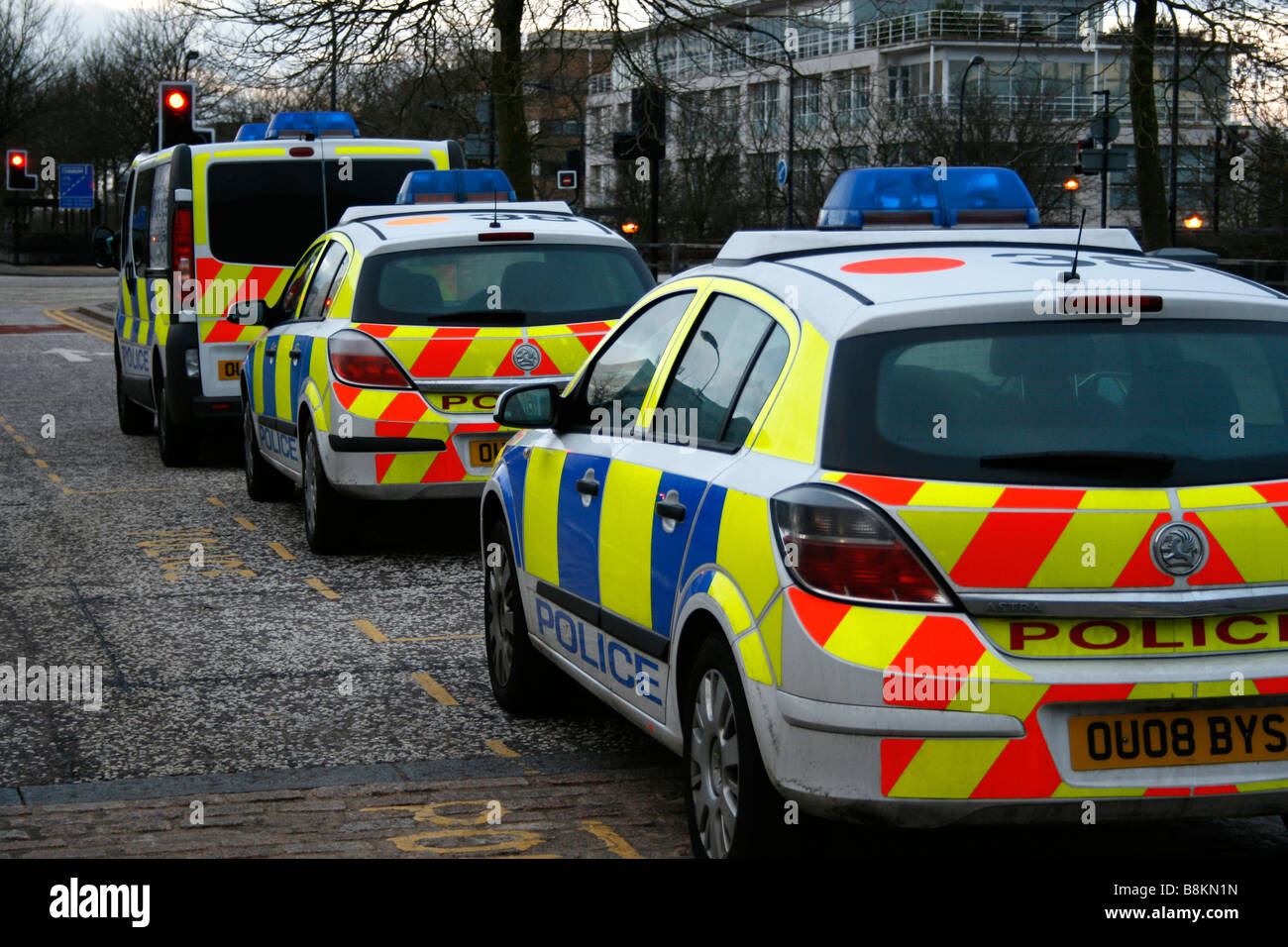 Police car cars and transit van row patrol traffic jam sandwich hi viz high visibility Stock Photo