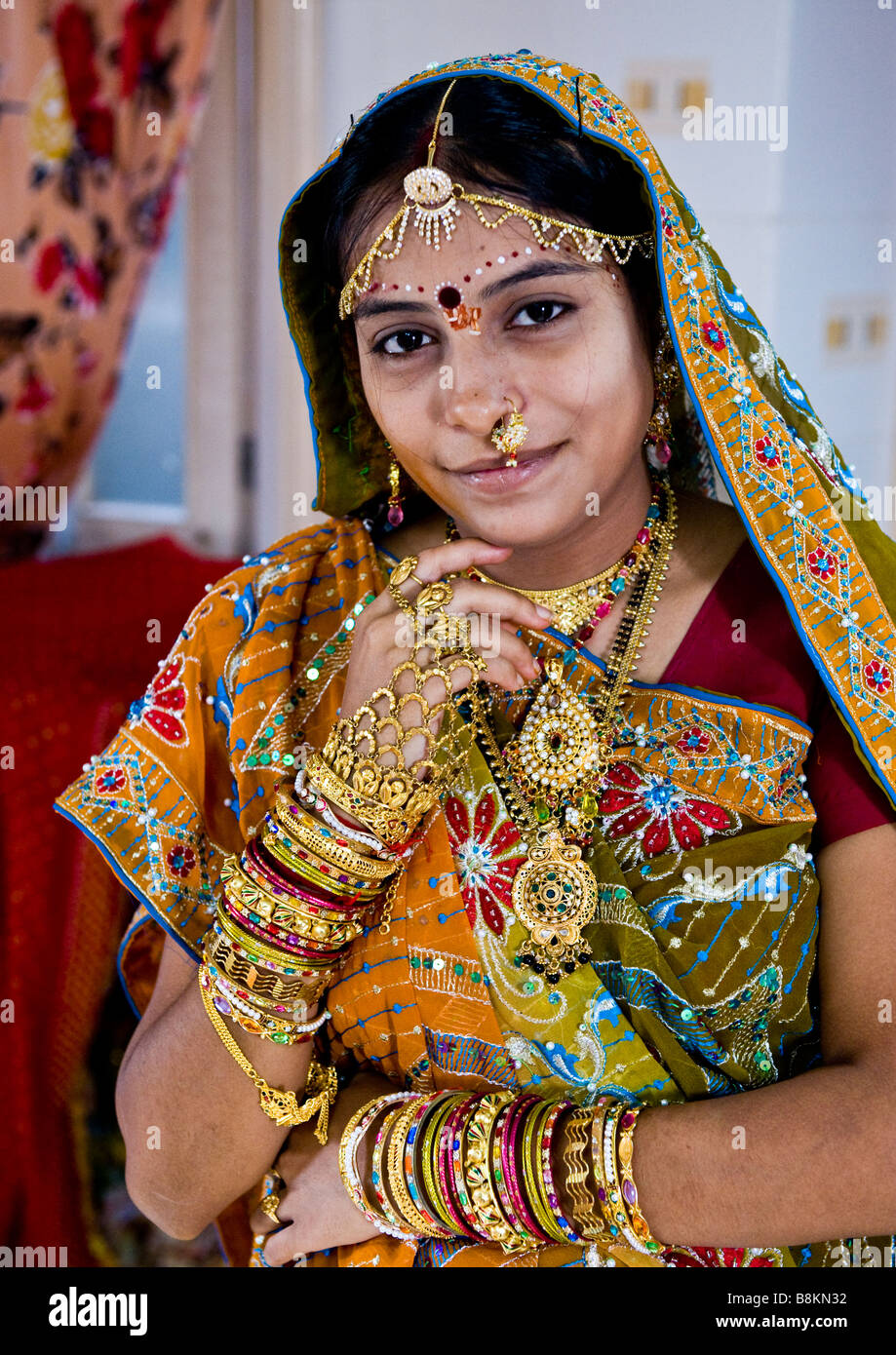 A very attractive Hindu bride in wedding sari, red blouse, gold bangles,  rings, head jewellery, necklaces. and lovely pendants Stock Photo - Alamy