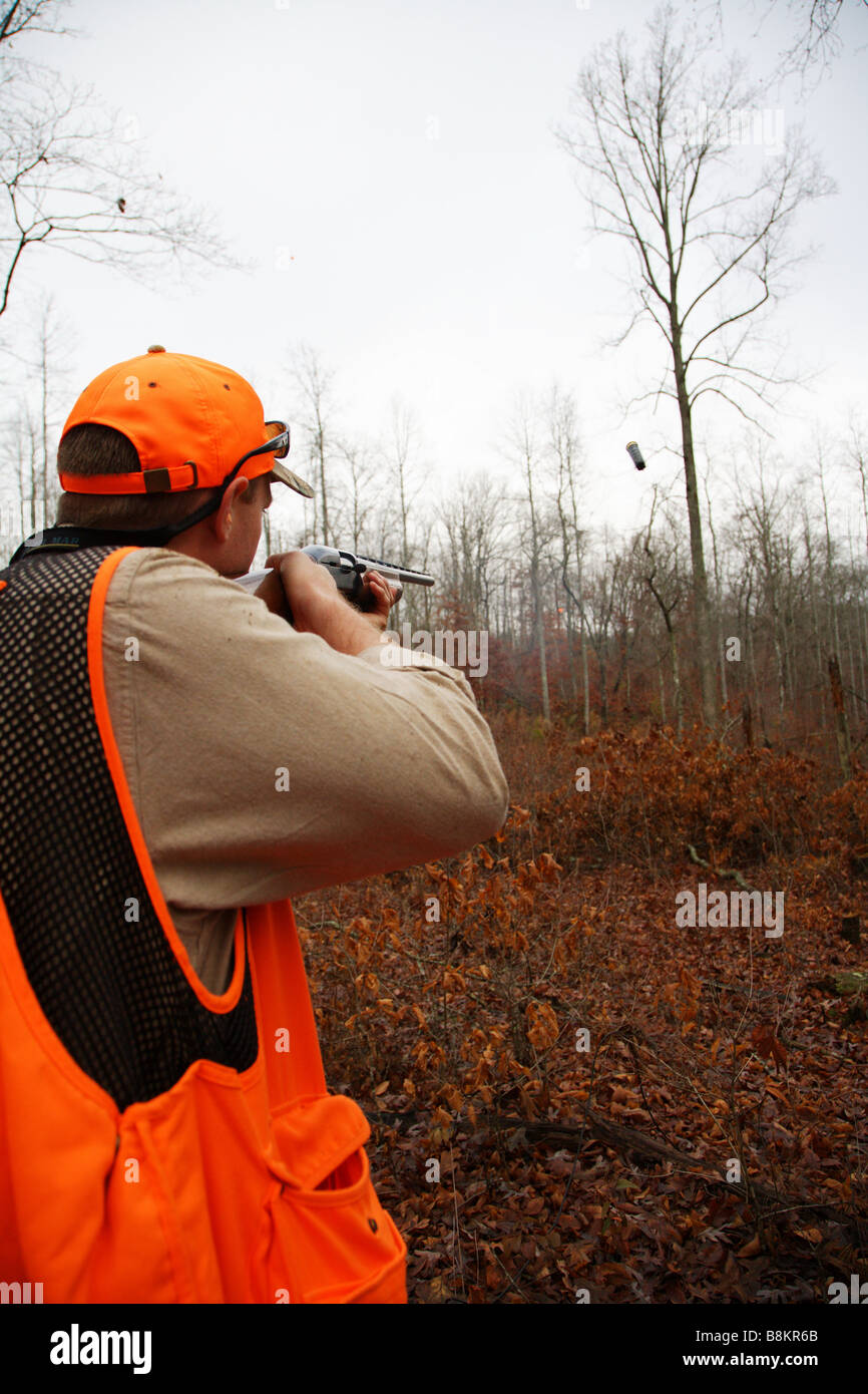 SPORTING CLAY SHOOTER FIRES AT TARGET SHELL EJECTING FROM GUN OUTDOOR