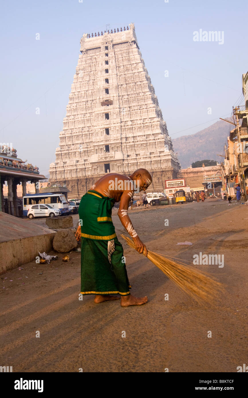 India Tamil Nadu Tiruvannamalai Brahmin priest sweeping area in front of small shrine Stock Photo