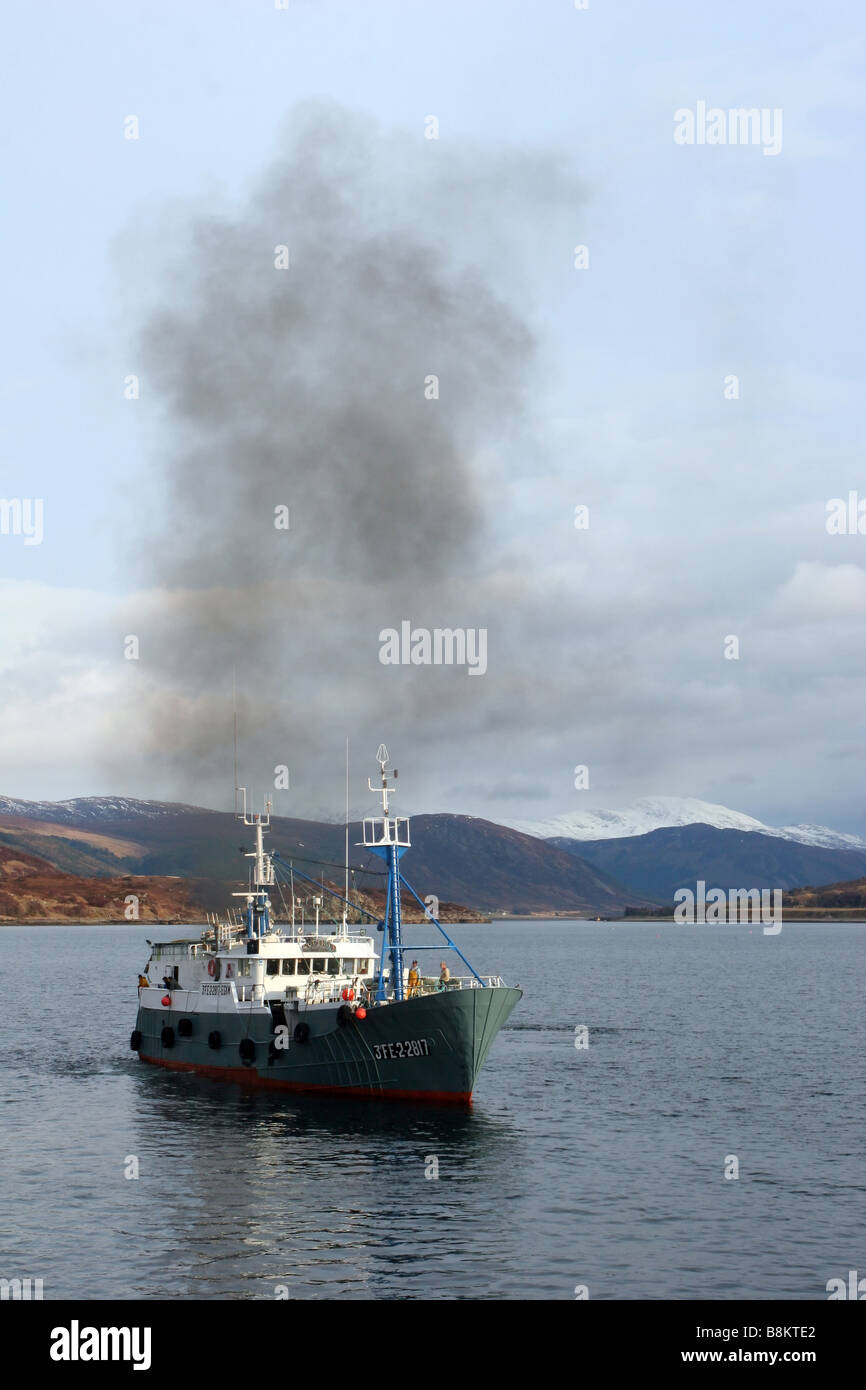 Fishing boat leaving Ullapool Harbour into Loch Broom Stock Photo