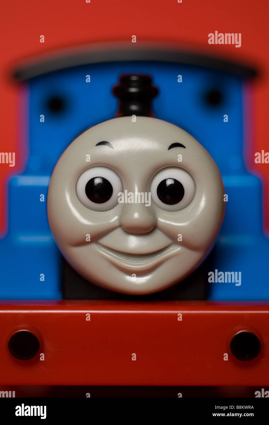 A closeup still life of a Thomas the Tank Engine toy on a red background. Stock Photo