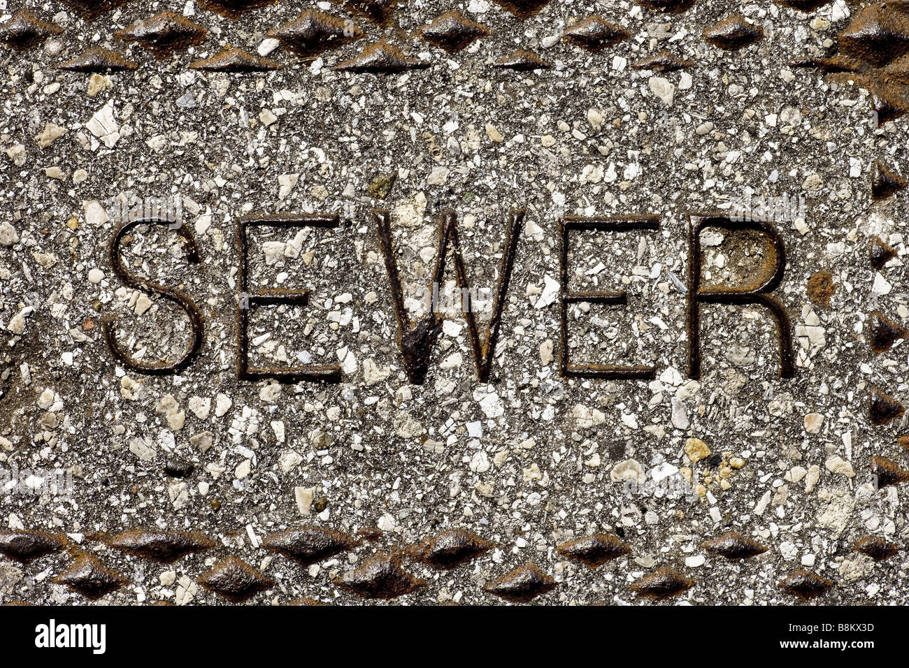 sewer sign on man hole cover background Stock Photo