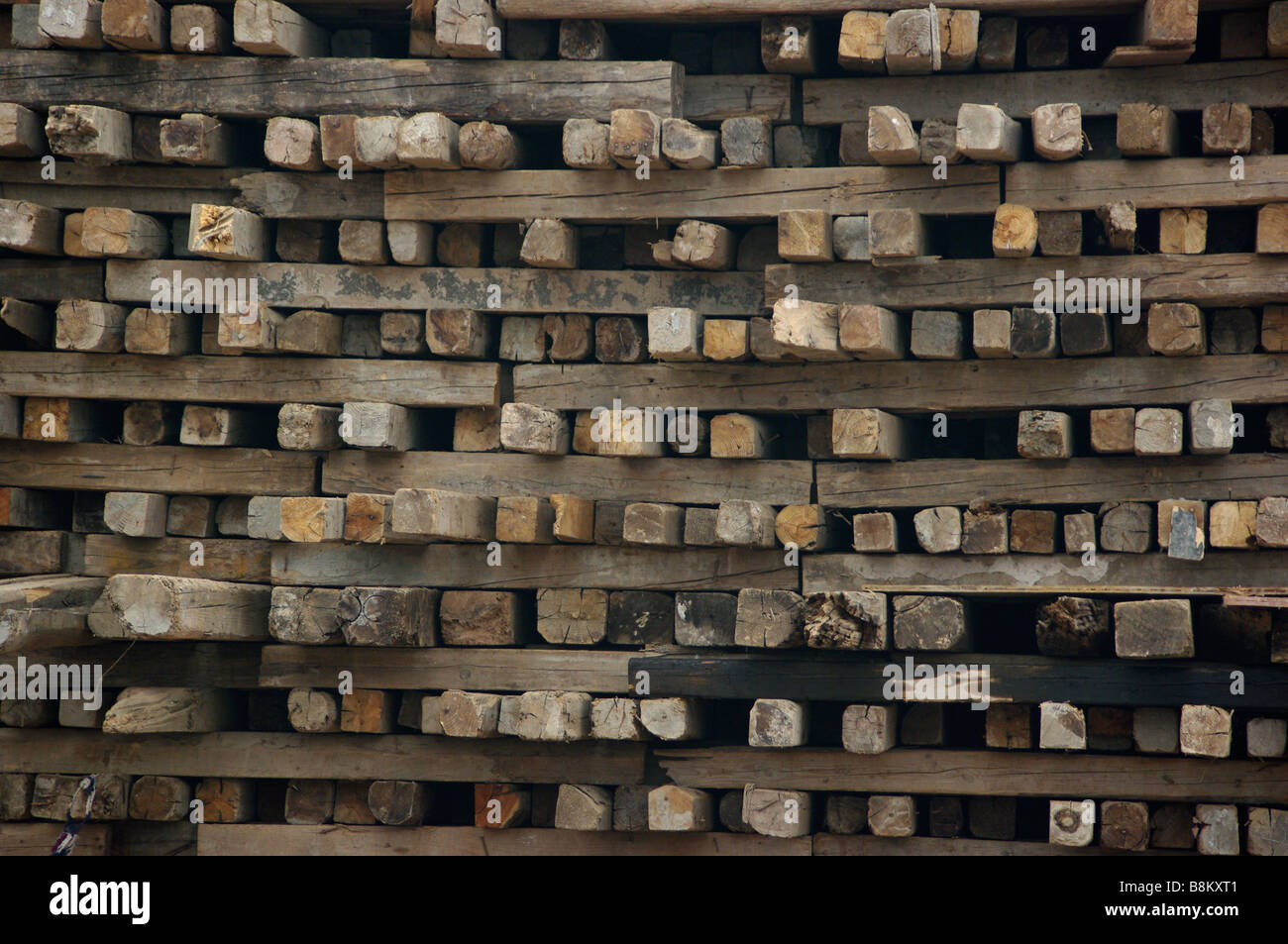 Logs, wood, planks and other lumber products stacked at construction site after forests and trees were harvested for building. Stock Photo