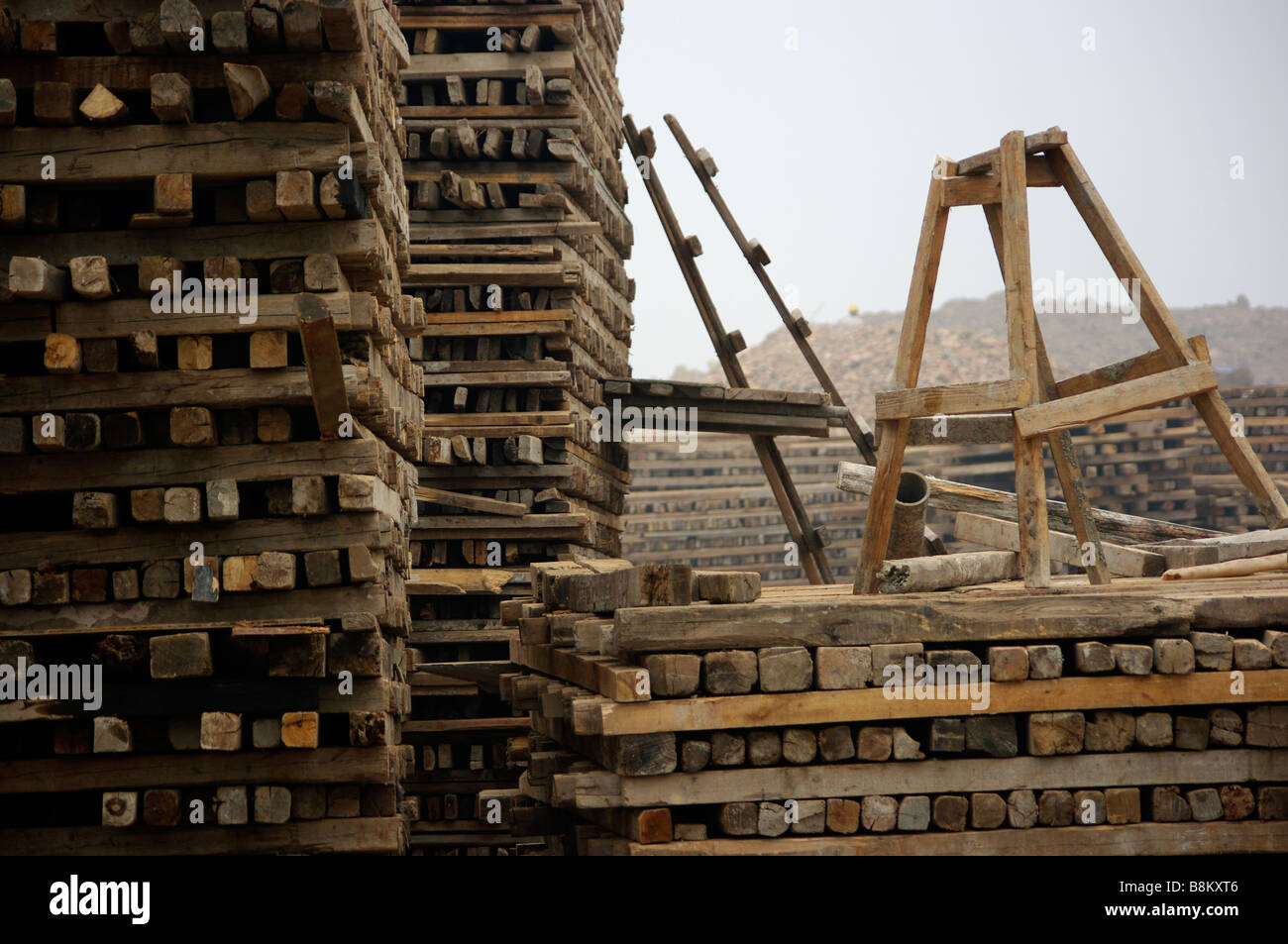 Logs, wood, planks and other lumber products stacked at construction site after forests and trees were harvested for building. Stock Photo