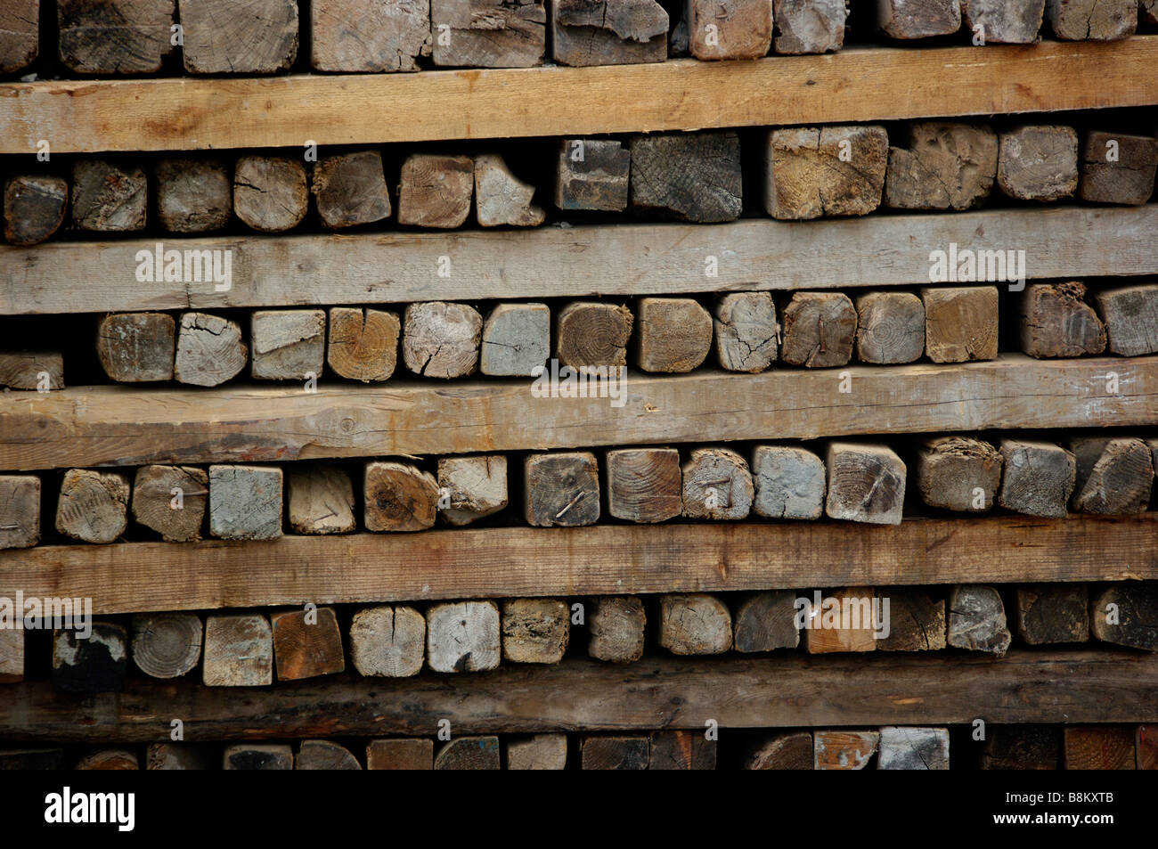 Logs, wood, planks and other lumber products stacked at construction site after forests and trees were harvested for building. Stock Photo