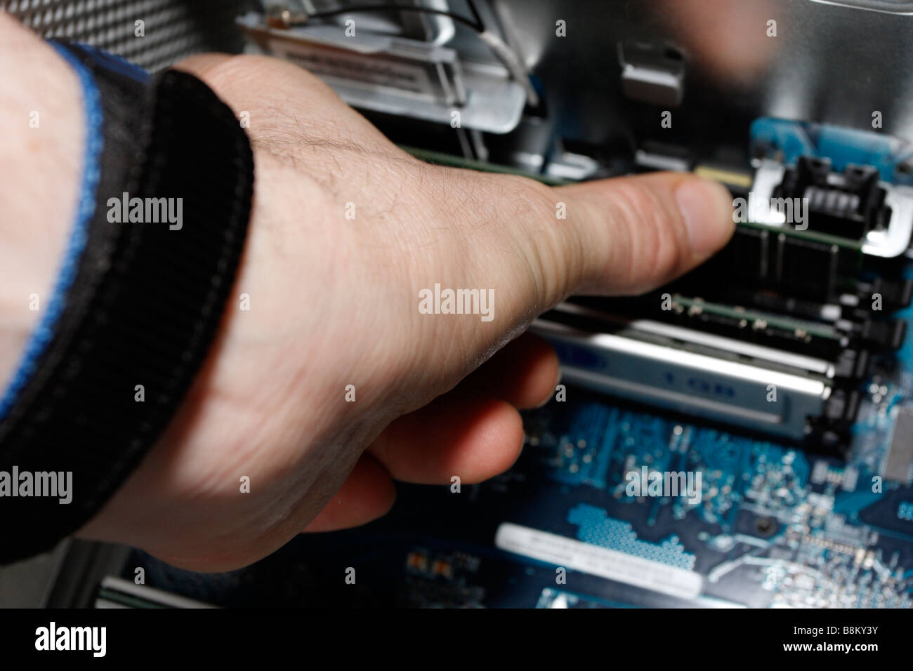 Male hand thumb setting RAM inside an Apple PowerMac G5, late 2004 dual 2gHz,  open Stock Photo