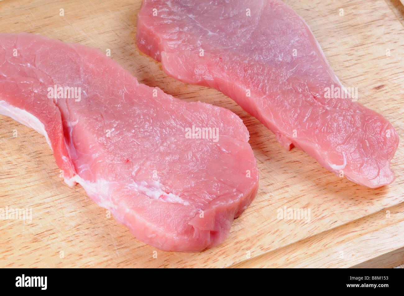 Fresh pork steak on wooden chopping board. Stock Photo