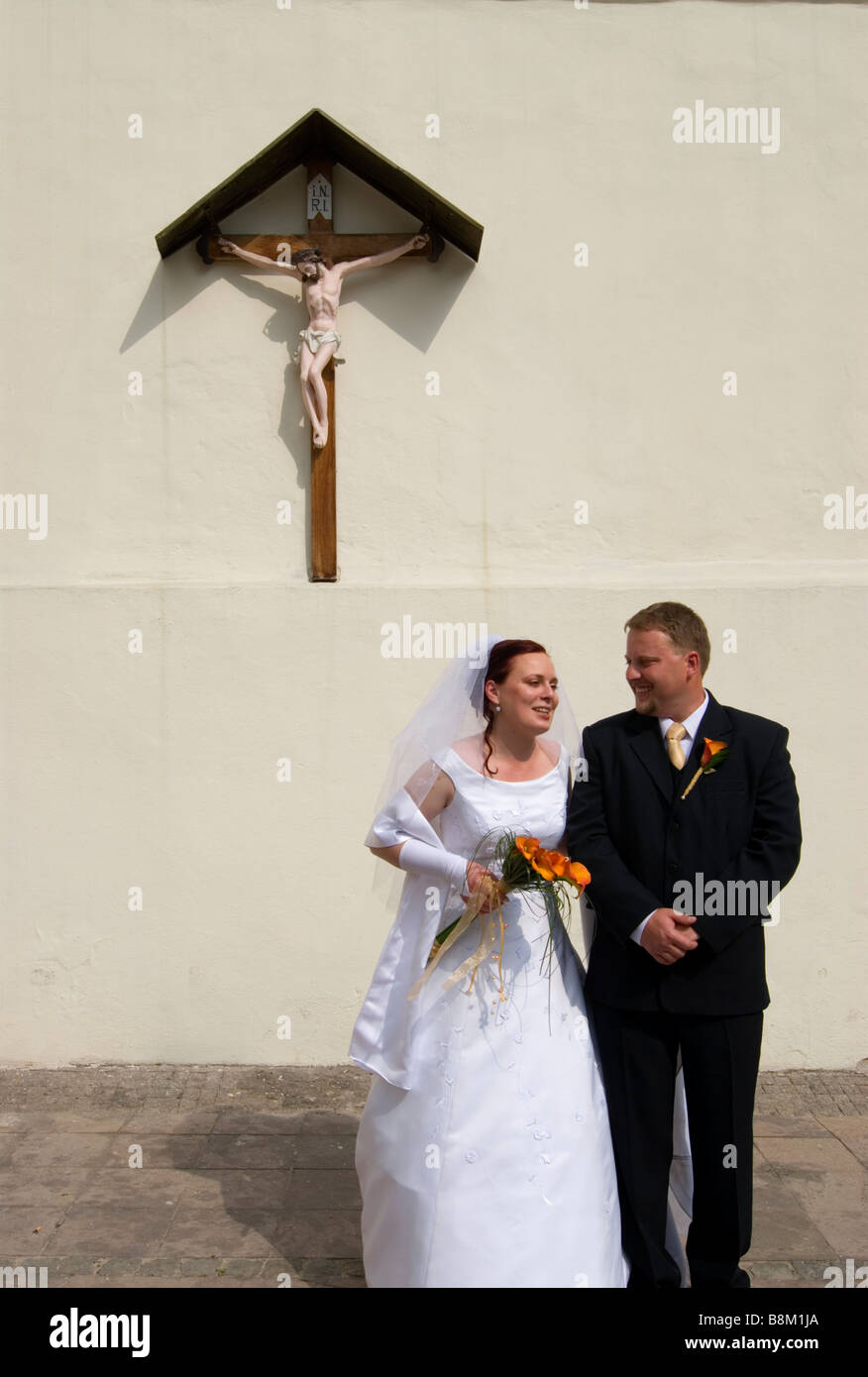 Newlyweds in front of the church of the Holy Cross in the castle complex of Banska Bystrica Stock Photo