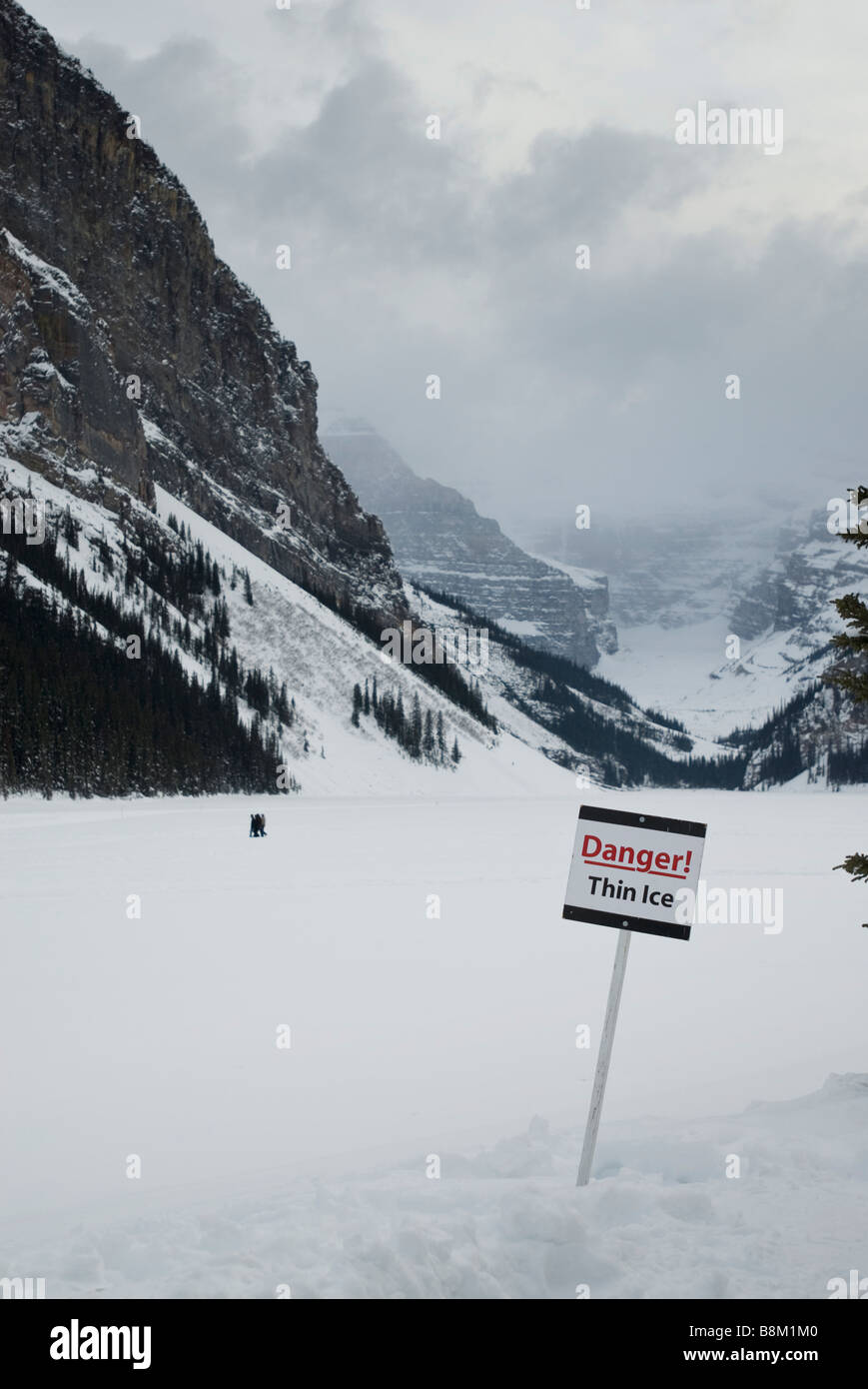 Danger Thin Ice sign on a frozen Lake Louise in Banff National Park, Alberta, Canada. Stock Photo
