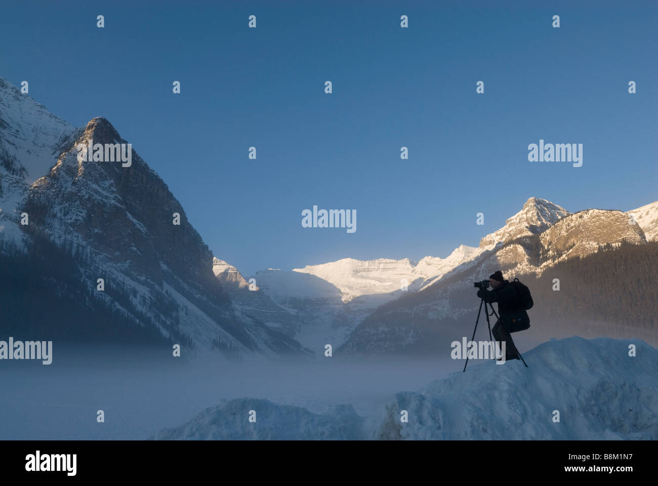 A photographer shoots a frozen Lake Louise in Banff National Park ...