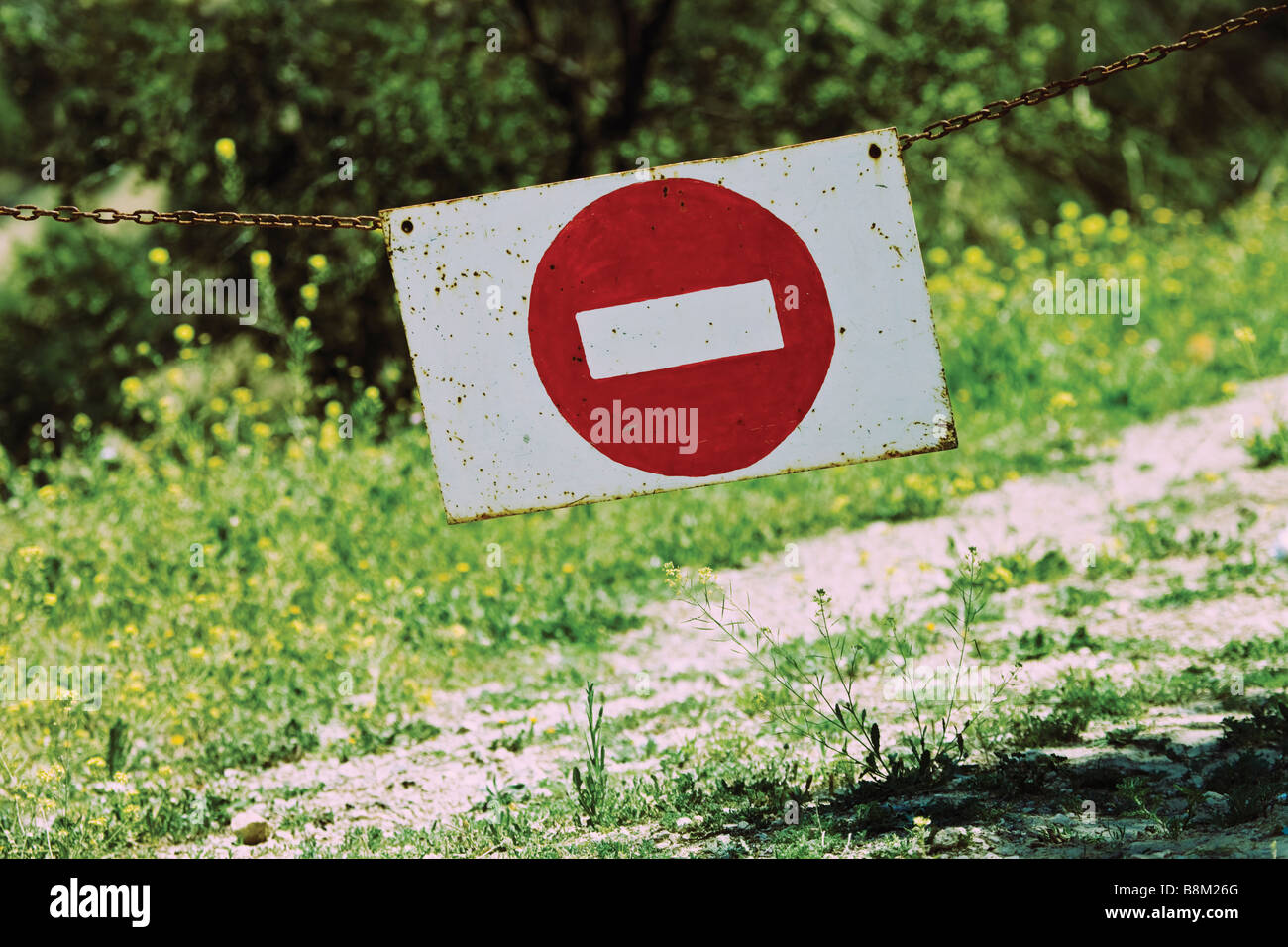No entry sign suspended on chain across country track at entrance to property Stock Photo