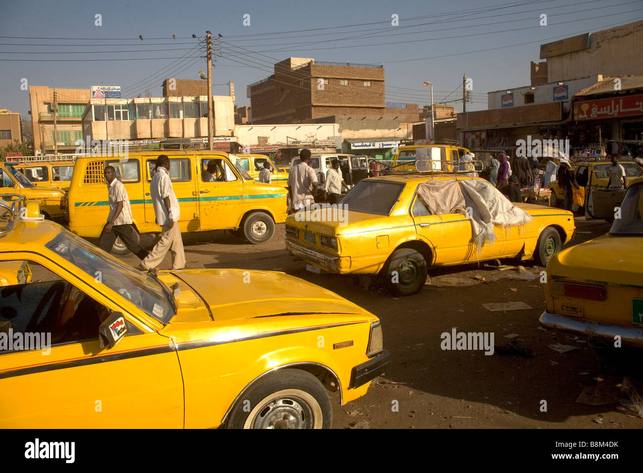 Yellow cab taxis wait for people in the streets at the market in Ommdurman, West Khartoum, Sudan Stock Photo