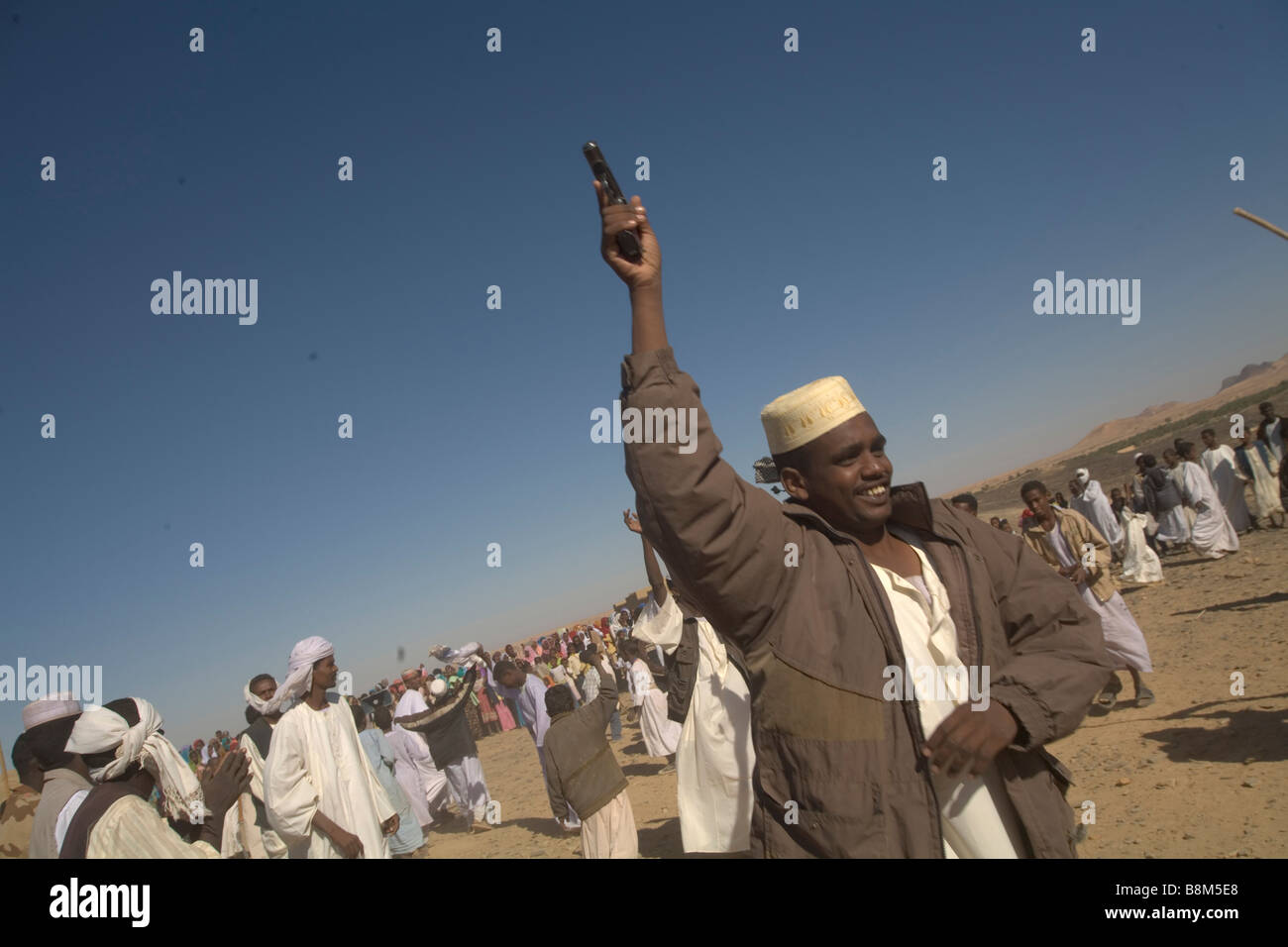 The guests dancing with guns at the muslim marriage ceremony in El Ar village at 4th Nile River catharact region Nubia Sudan Stock Photo