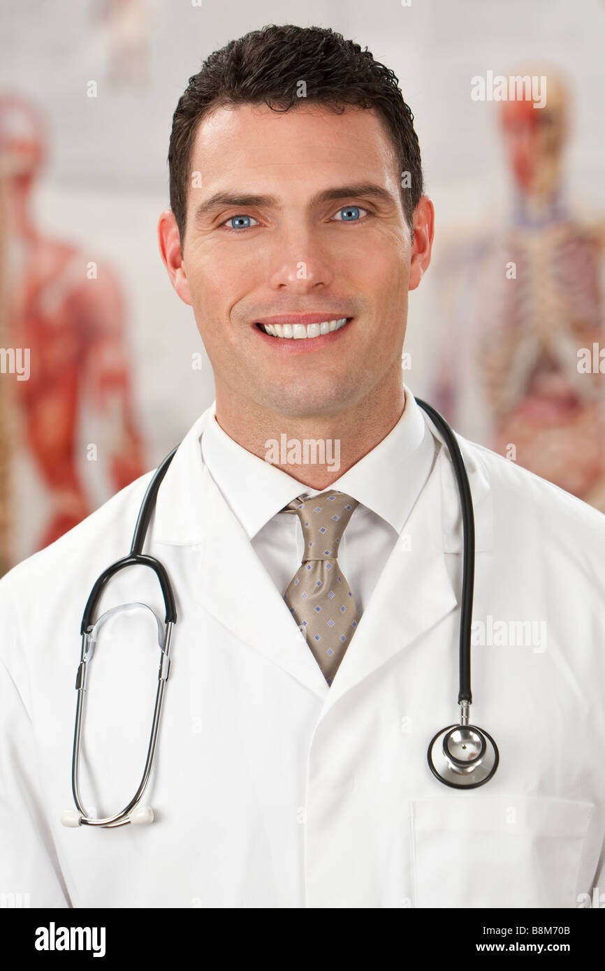 A male doctor with medical charts out of focus behind him Stock Photo