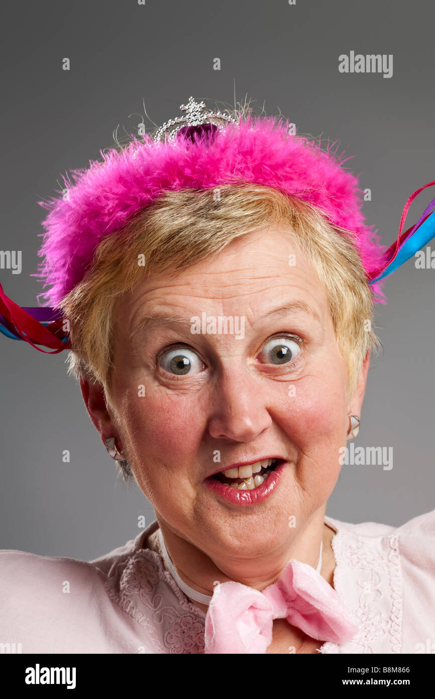Mature woman with silly expression wearing pink tiara Stock Photo