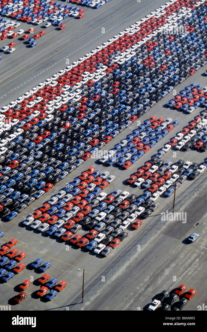 New cars sit in rows on dock after being unloaded from ship economy oil mileage market sell overload inventory auto vehicle Stock Photo