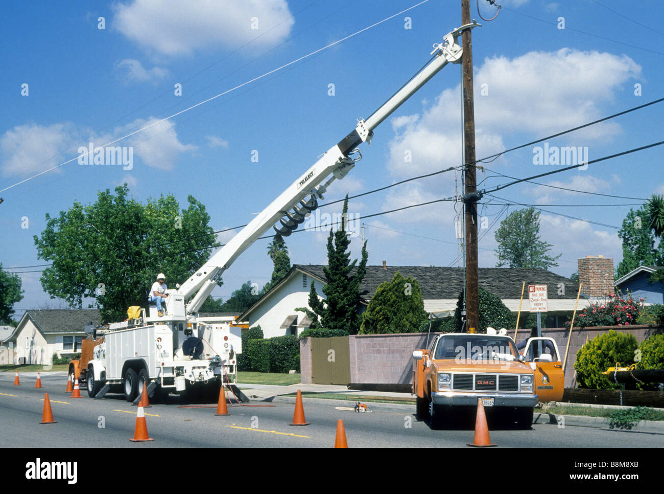 Electric crew holds power pole in place with special crane truck as