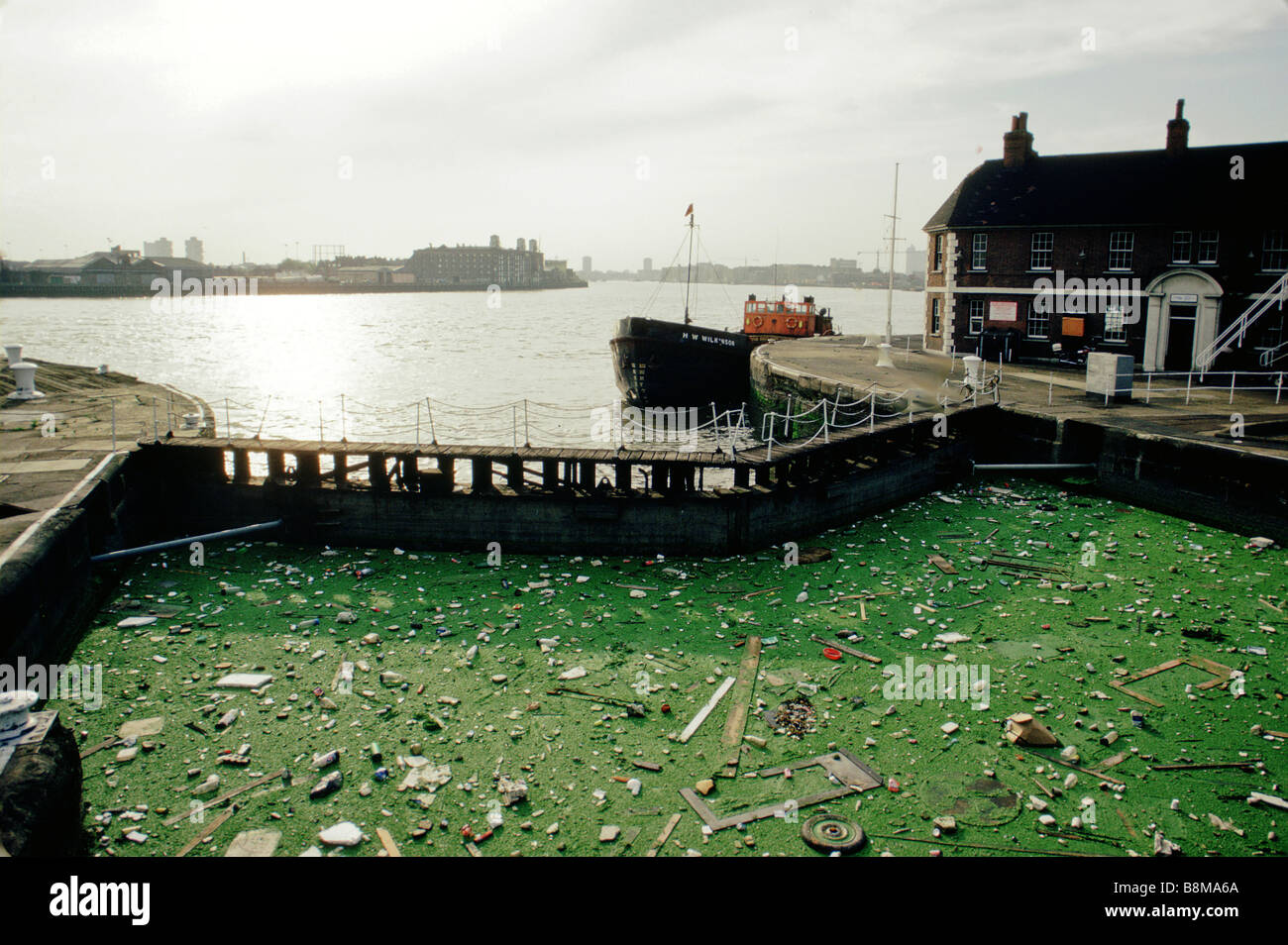 Detritus and pollution collected at a gate on the River Thames south of London Stock Photo
