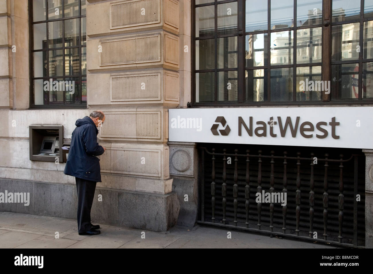 Customer withdrawing money from NatWest ATM in City of London Stock Photo