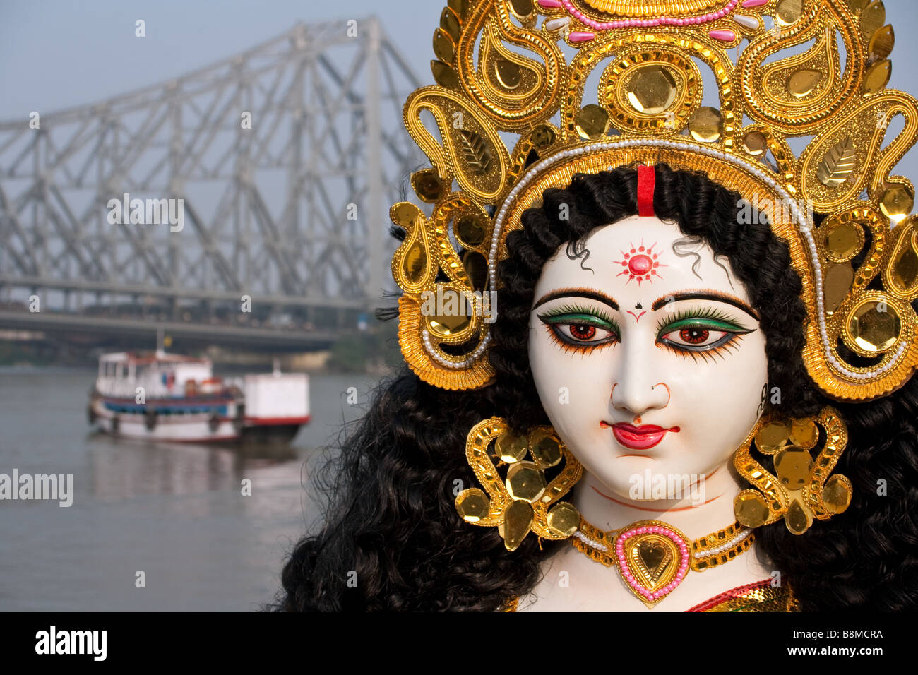 Goddess Saraswati with Calcutta's Howrah Bridge in the background, India Stock Photo