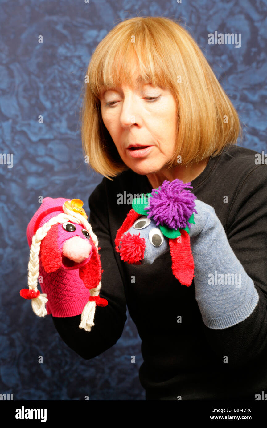 Female puppeteer performing with hand manipulated character puppets created from socks. Stock Photo