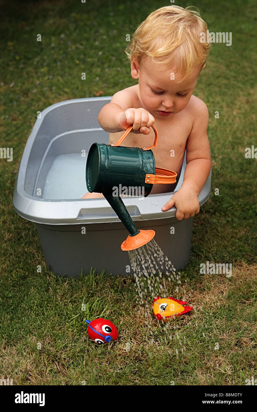 Fish out of water. Baby boy saving fish Stock Photo