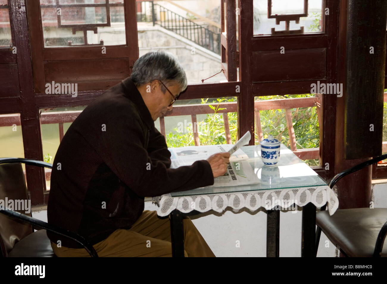 reading his newspaper in a traditional Tea house in the Confucius temple area in Nanjing. Stock Photo