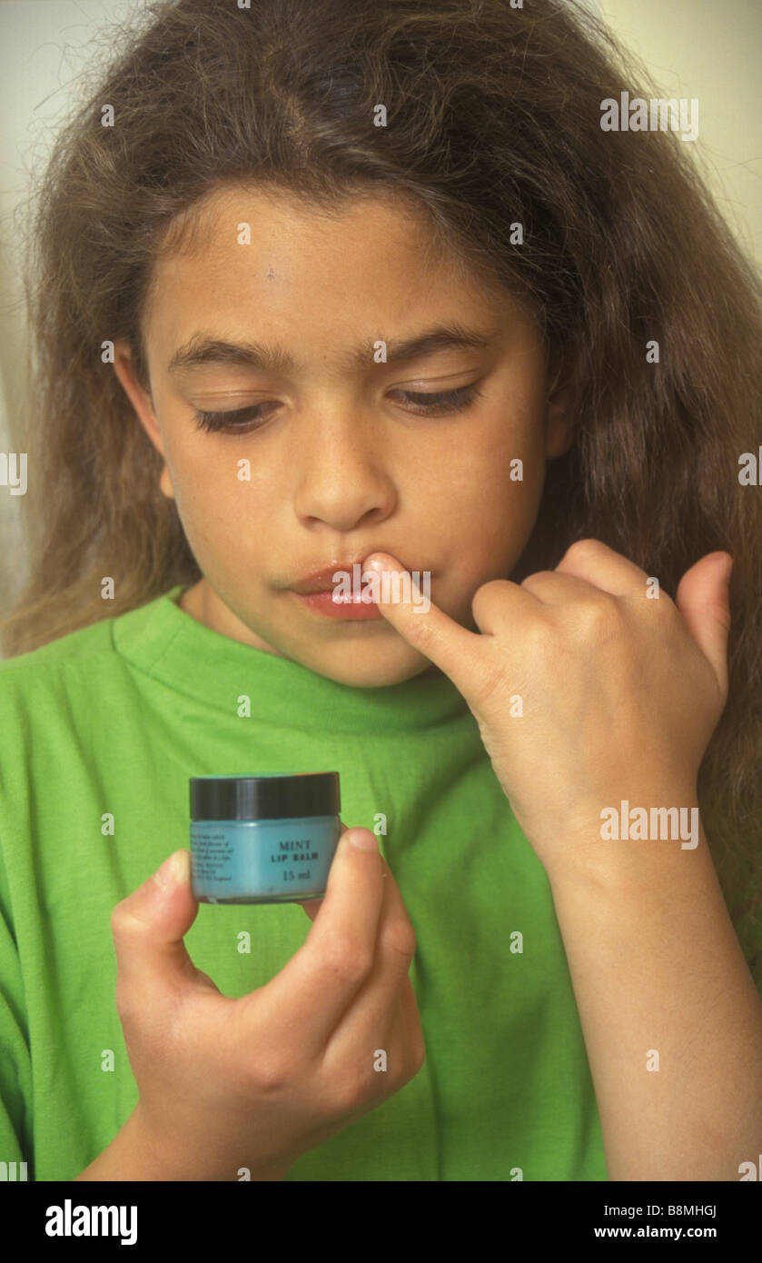girl rubbing lip balm into her lips Stock Photo Alamy