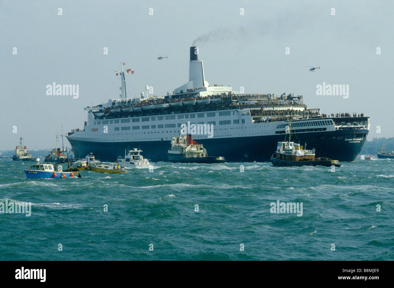 Falklands war Queen Elizabeth QE2 leaves Southampton dock for the Falklands Conflict, a flotilla of boats seeing her off May 1982 1980S UK HOMER SYKES Stock Photo