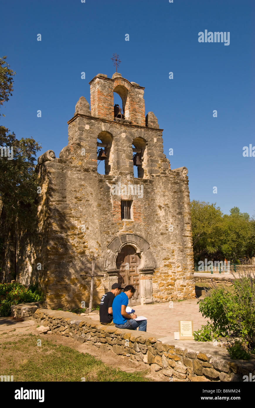 Two college art students drawing in front of Mission Espada, San Antonio Texas tx Missions National Park Stock Photo