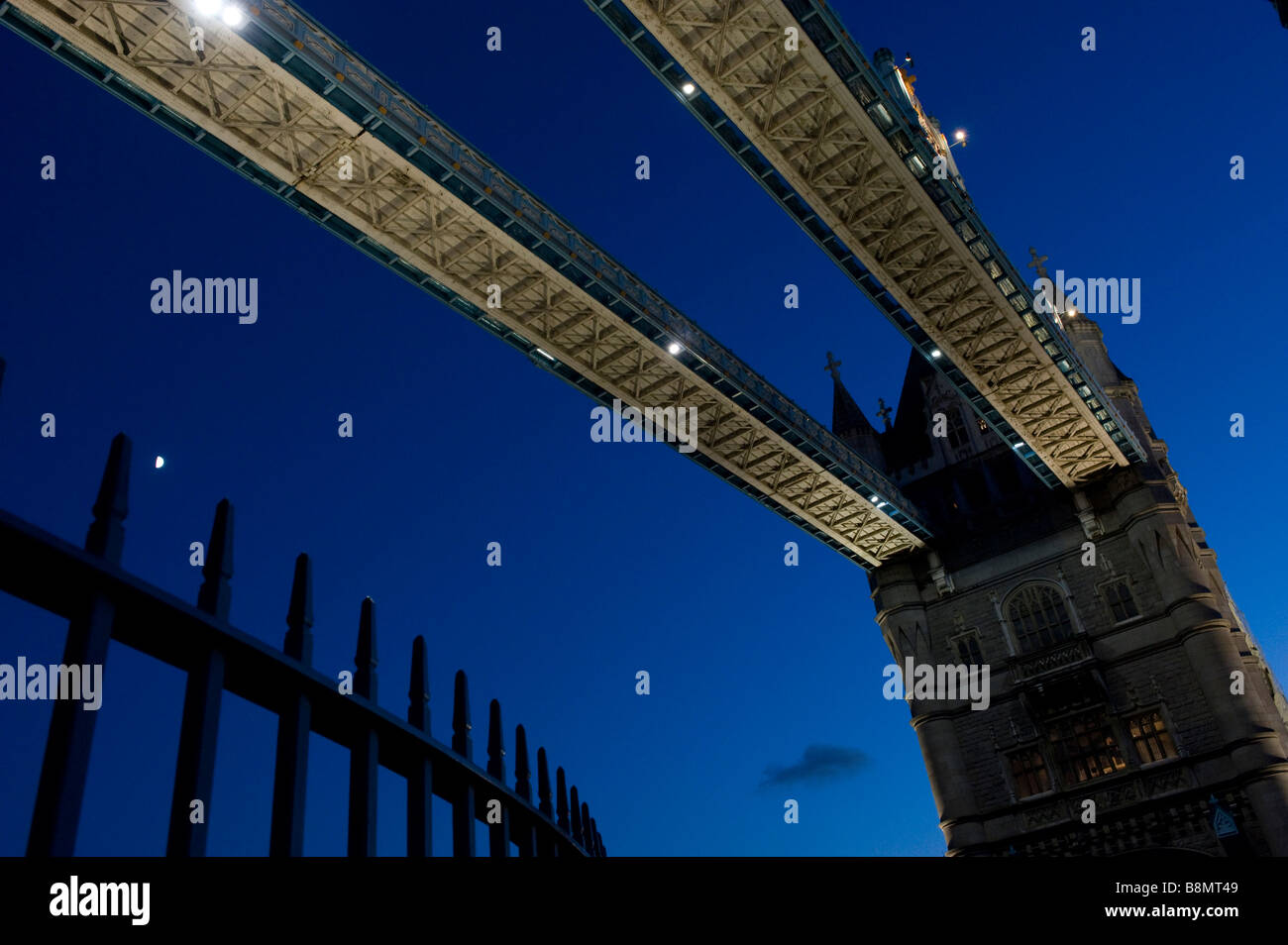 Tower Bridge on the Thames in London at night with the moon The bridge opens for shipping to go through Stock Photo
