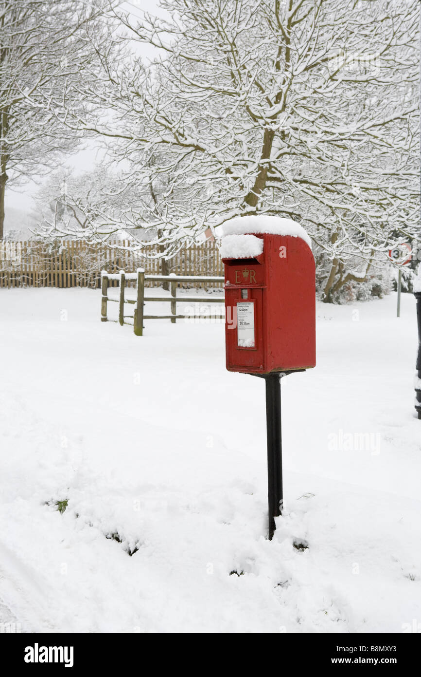 red post box in the snow in the village of Askett, Buckinghamshire, England Stock Photo