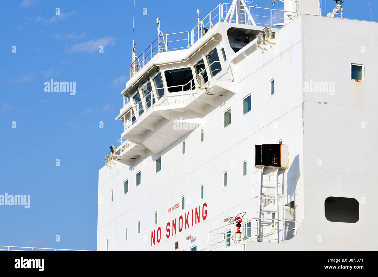 Ships bridge with windows 'no smoking sign' and [clear blue sky] Stock Photo