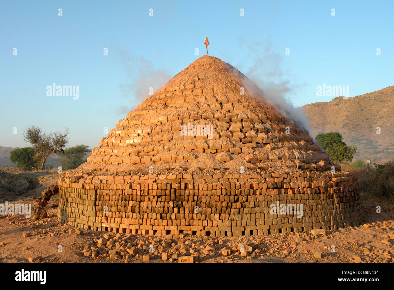 traditional indian clay brick kiln smoking in the morning Stock Photo