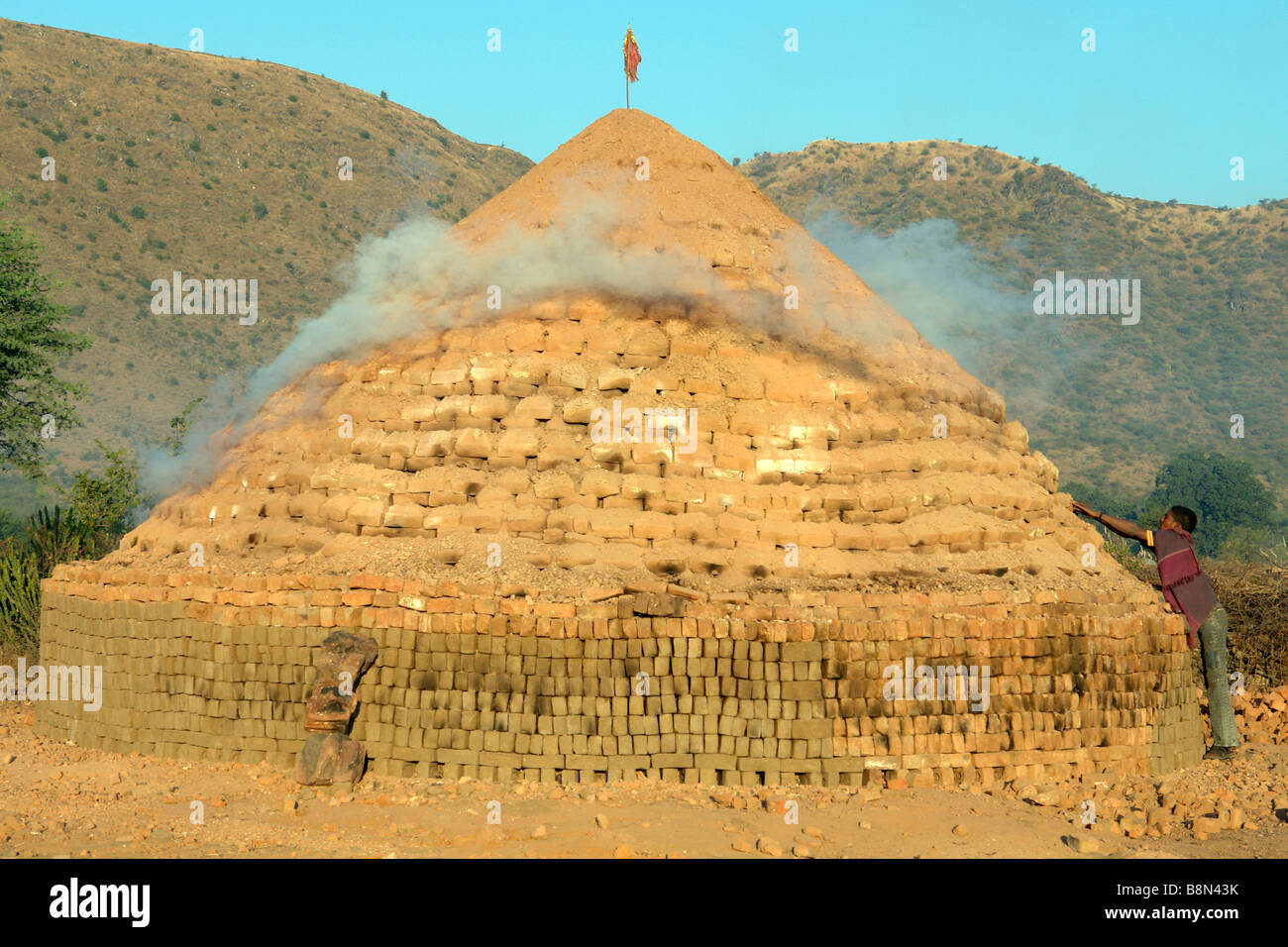 traditional indian clay brick kiln smoking by dawn light Stock Photo
