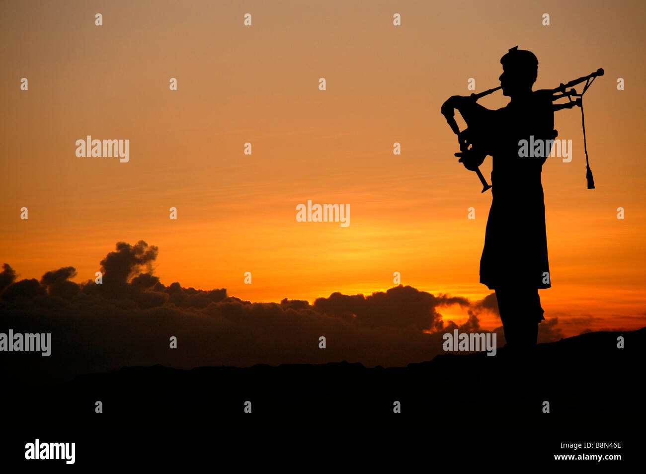 Silhouette of a kilted bagpiper. Stock Photo