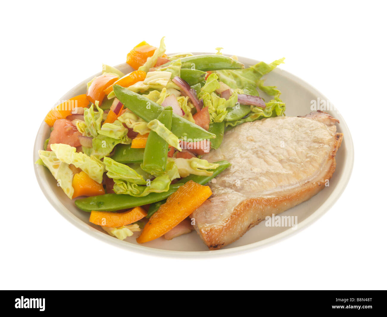 Freshly Grilled Lean Pork Loin Steak With A Fresh Healthy Summer Salad Isolated Against A White Background With No People And A Clipping Path Stock Photo
