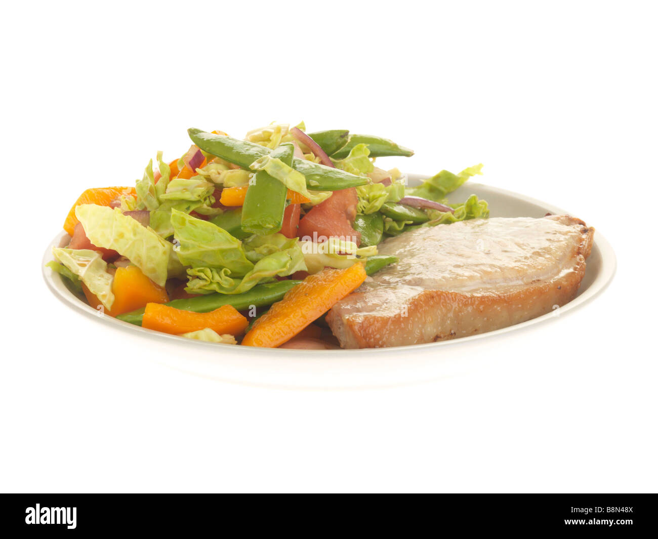 Freshly Grilled Lean Pork Loin Steak With A Fresh Healthy Summer Salad Isolated Against A White Background With No People And A Clipping Path Stock Photo