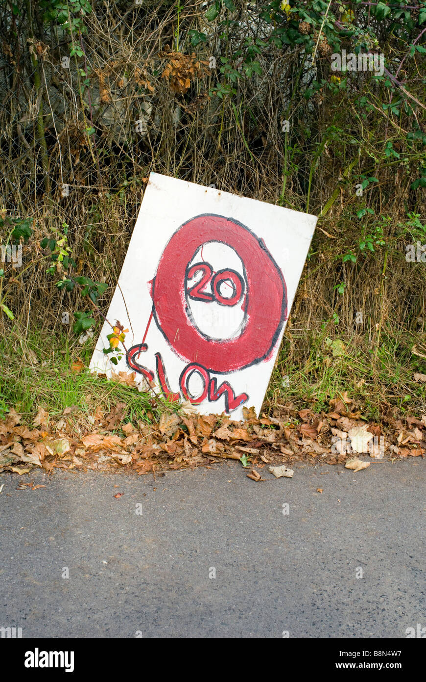 A hand painted road sign 20 SLOW on a country lane in East Sussex. England. Stock Photo