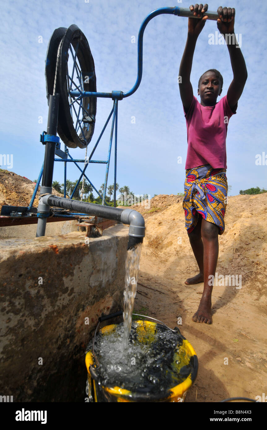 Child pumps water from a well, The Gambia, West Africa Stock Photo