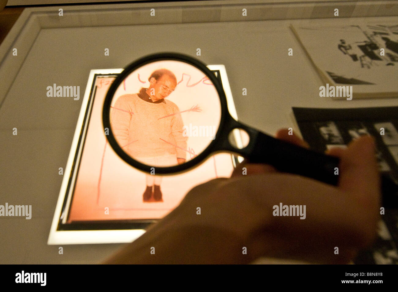 Visitor viewing an exhibit using a magnifying glass at the Museum of modern art Stock Photo