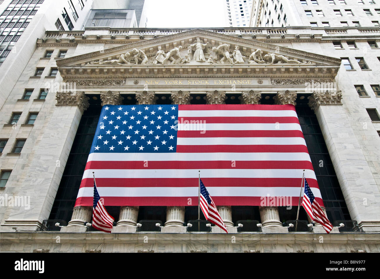United States flag on New York Stock exchange building, Wall street Manhattan Stock Photo
