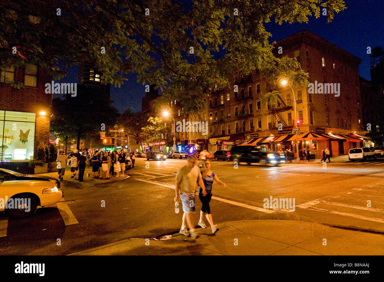 Pedestrians walking along 93rd street at night Stock Photo